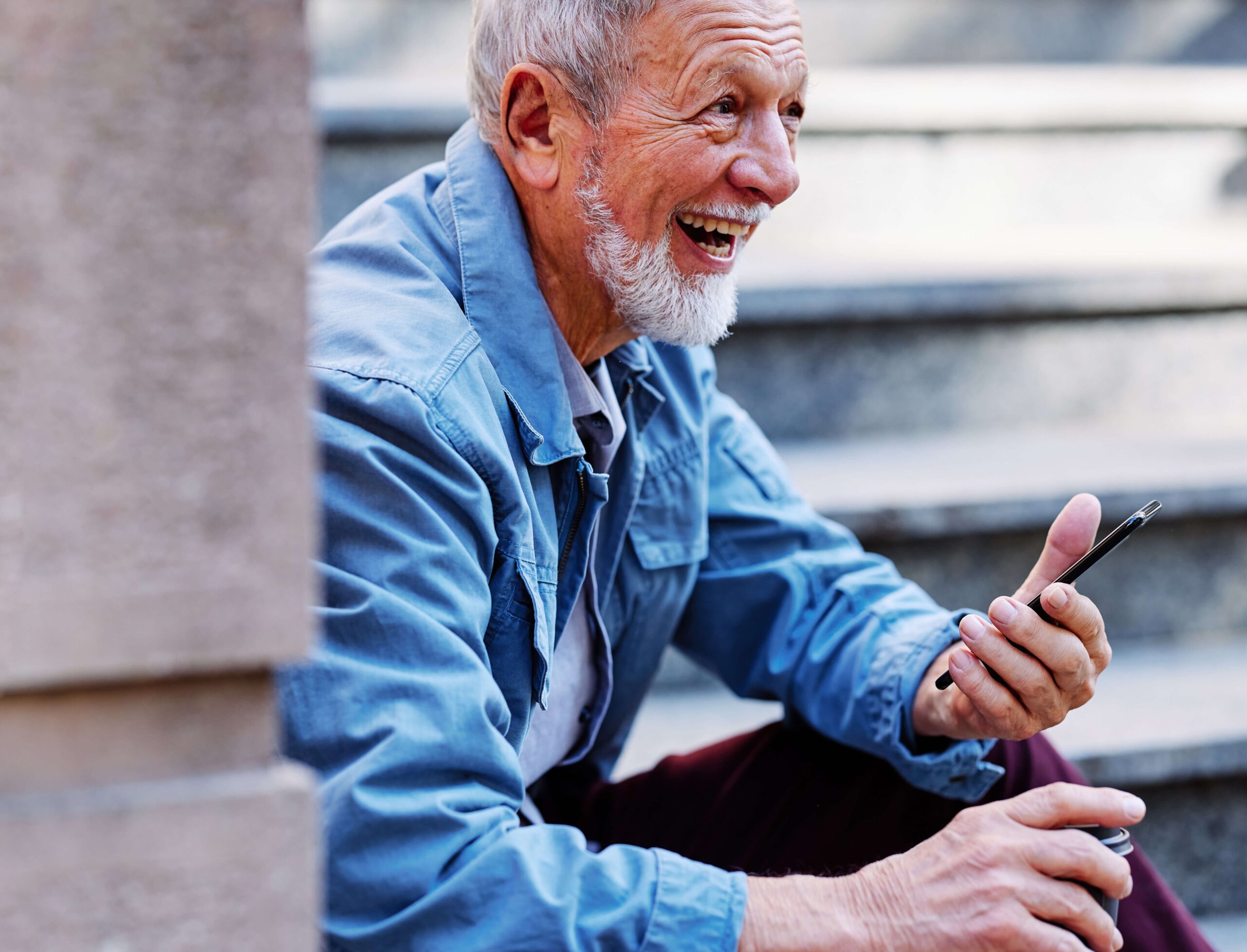 Old man laughing while sitting