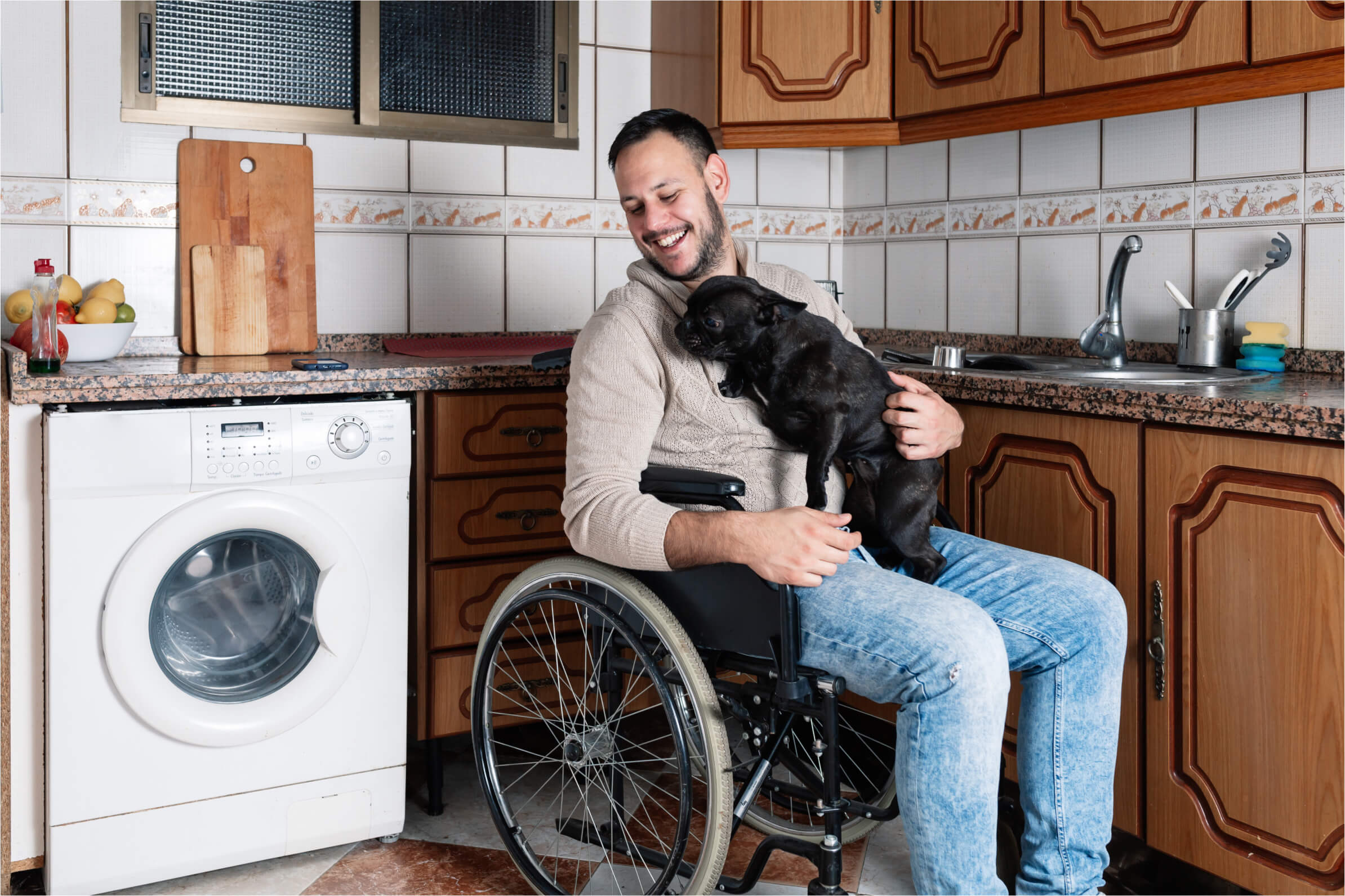 Men on wheelchair smiling with dog