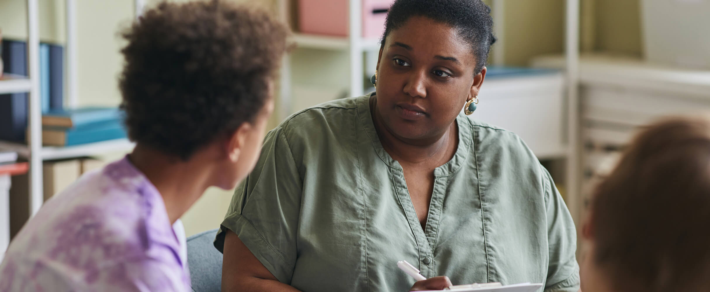 Female Therapist talking with a young patient, one on one.