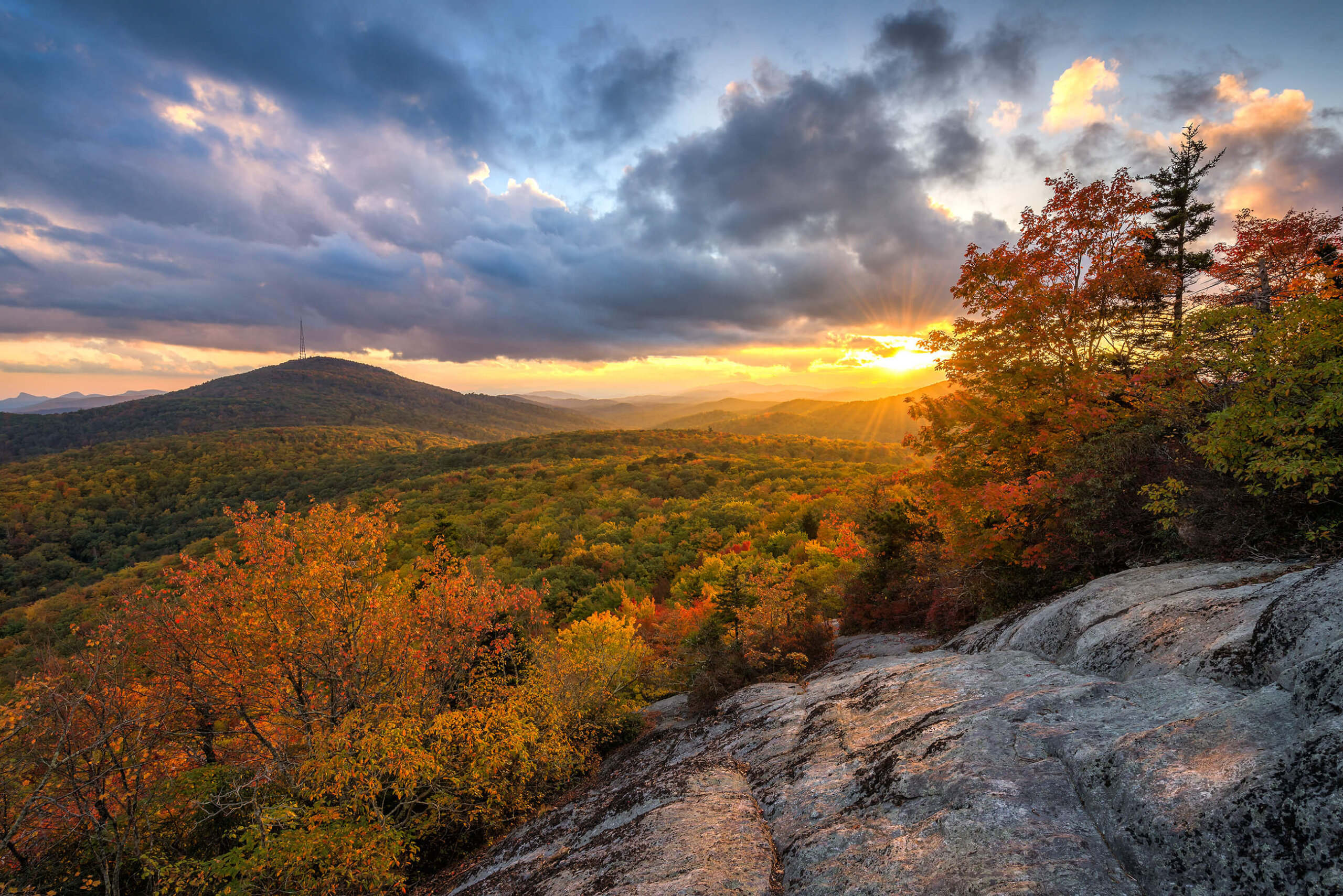 Mountains and trees in a sunset with blue cloudy sky